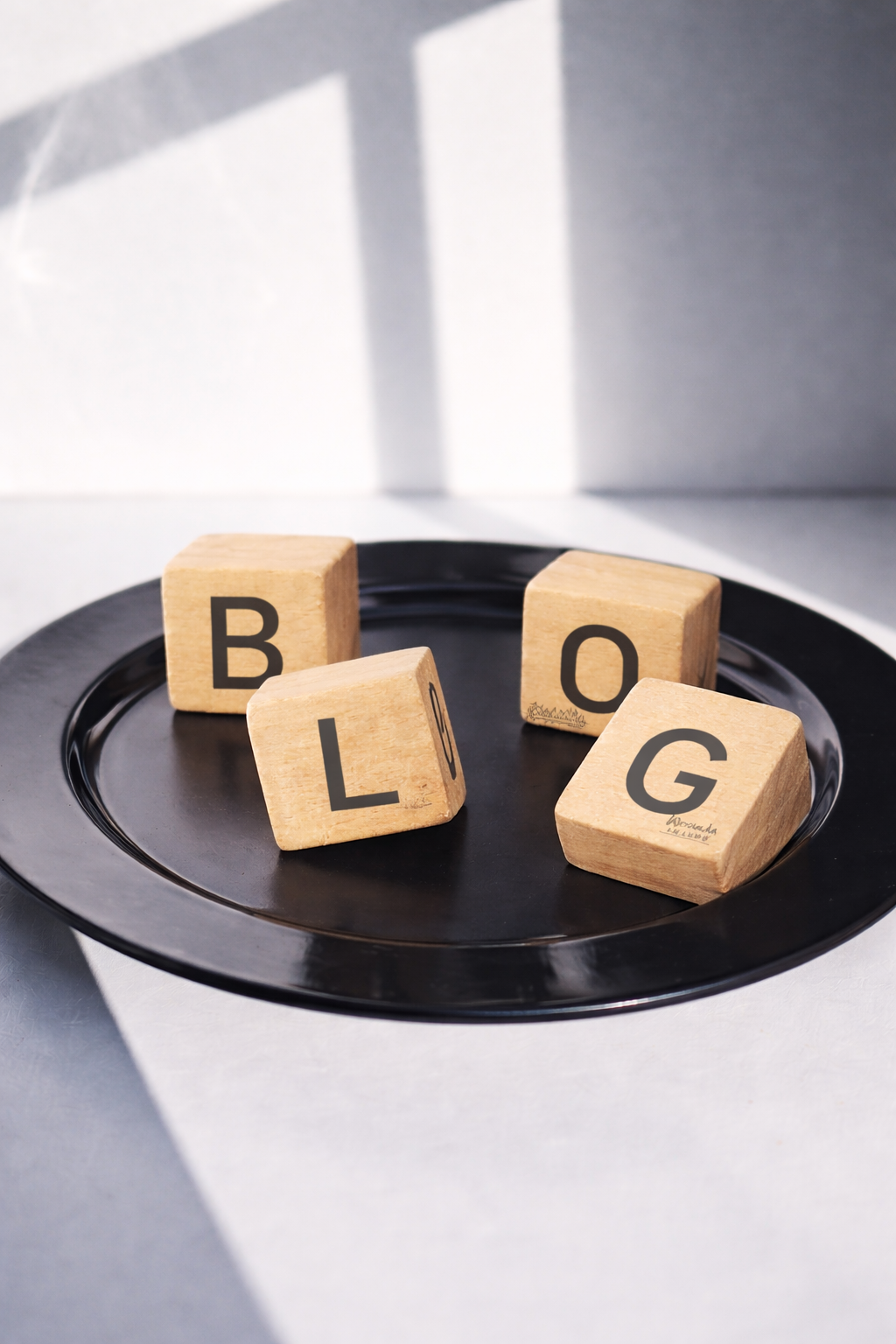 Drewniane klocki z literami BLOG na czarnym talerzu